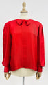 Blusa rossa con fiocco